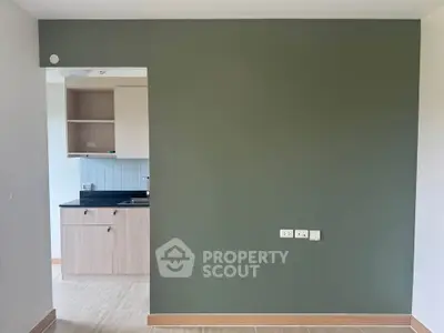 Modern apartment with sleek kitchen and stylish green accent wall, perfect for urban living.