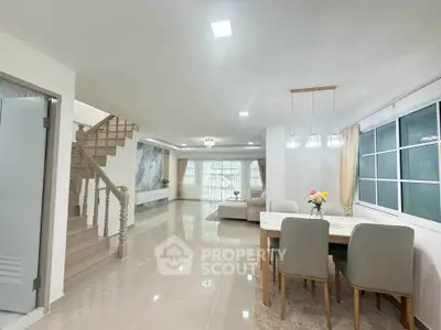 Spacious open-plan living and dining area with modern decor and elegant lighting.