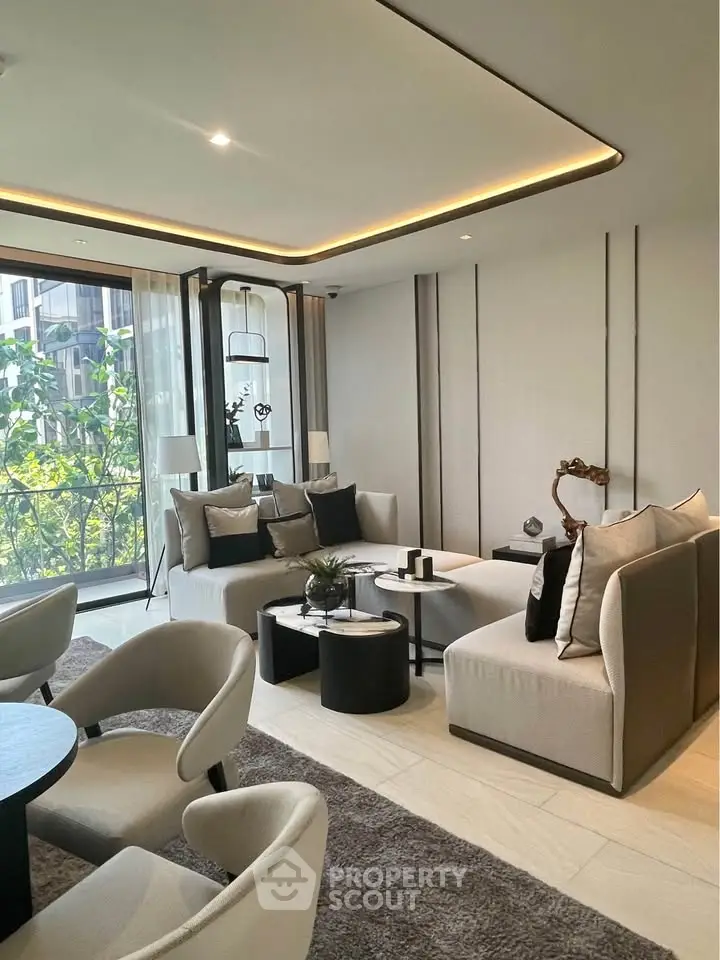 Luxurious modern living room with elegant furniture and large windows offering a serene view.