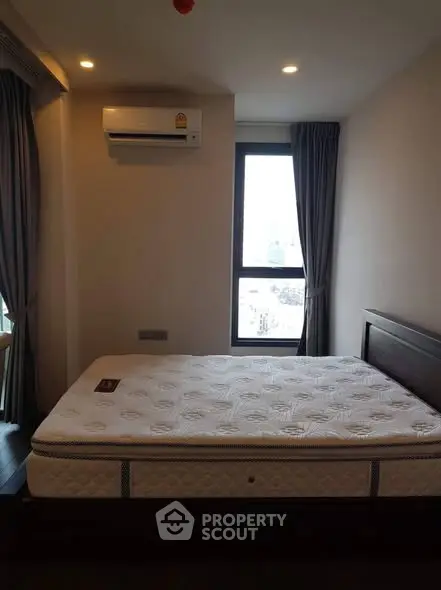 Cozy bedroom with large window and air conditioning in modern apartment