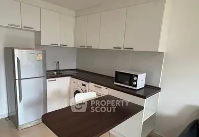 Compact kitchen with modern appliances including fridge, washing machine, and microwave.