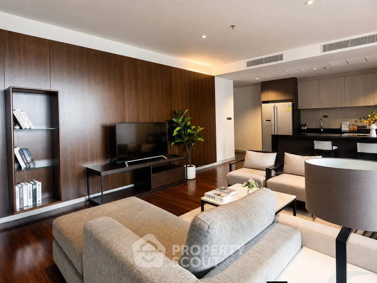 Spacious modern living room with open kitchen, stylish furniture, and elegant wooden accents.