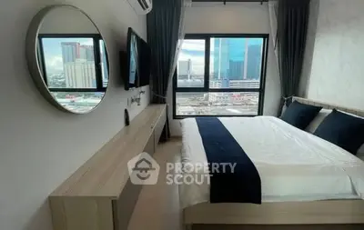 Modern bedroom with city view, featuring sleek design and large windows for natural light.