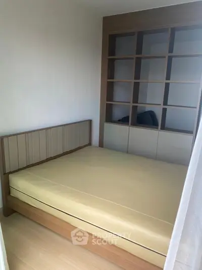 Cozy bedroom with built-in shelving and modern design, perfect for urban living.