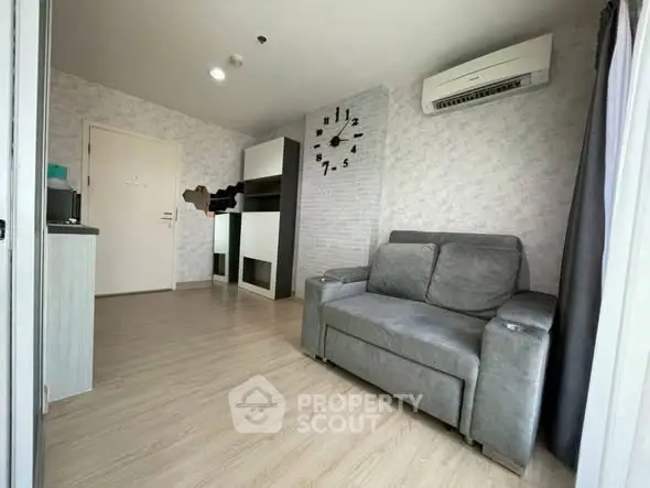 Modern living room with sleek design and air conditioning, featuring a stylish clock and comfortable seating.