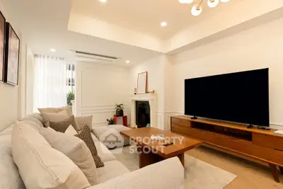 Modern living room with cozy sofa, large TV, and elegant decor