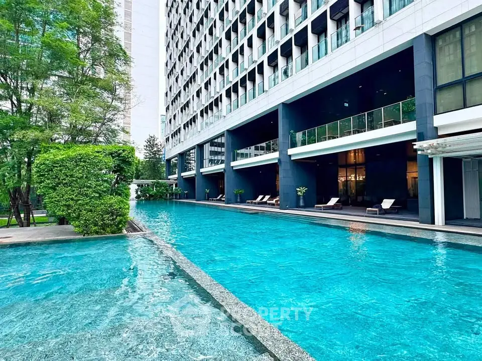 Luxurious apartment building with stunning pool and lush greenery, perfect for relaxation and leisure.