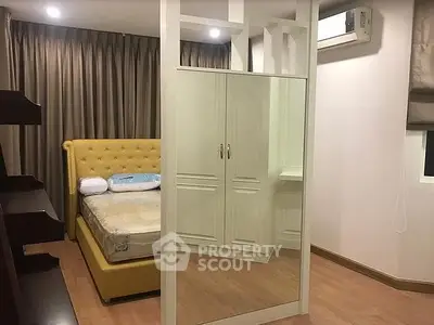 Modern bedroom with stylish yellow bed and mirrored wardrobe in cozy apartment.
