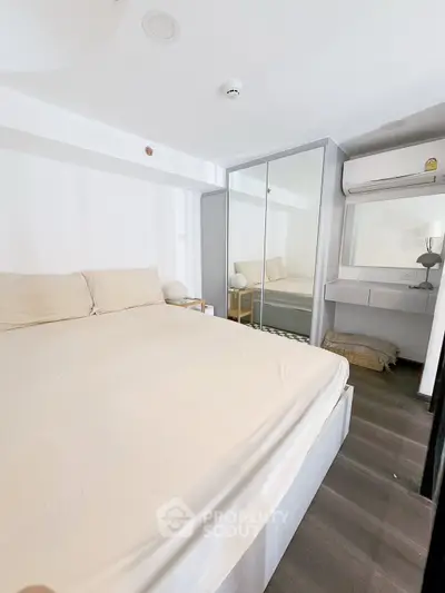 Modern bedroom with mirrored wardrobe and cozy bed setup