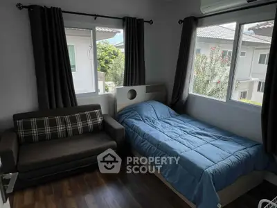 Cozy bedroom with large windows and modern decor in a bright home.