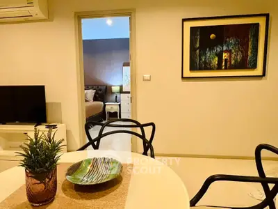Stylish modern living room with elegant decor and a glimpse into a cozy bedroom.