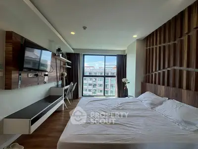 Modern bedroom with large window and stylish wooden accents, offering a bright and inviting atmosphere.