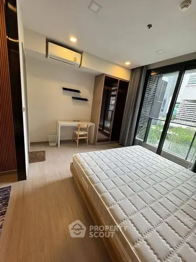 Modern bedroom with large window and minimalist decor in urban apartment