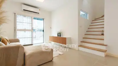 Modern living room with minimalist decor and staircase in bright natural light