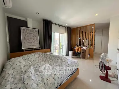 Spacious bedroom with modern decor and balcony access in a stylish home.