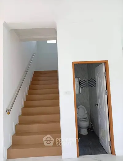 Modern interior with staircase and bathroom, showcasing sleek design and functionality.