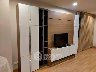 Modern living room with sleek entertainment center and wooden flooring