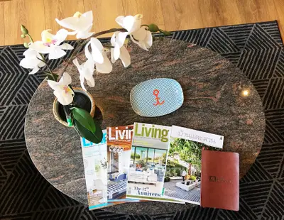 Elegant coffee table with magazines and orchid centerpiece in modern living room.