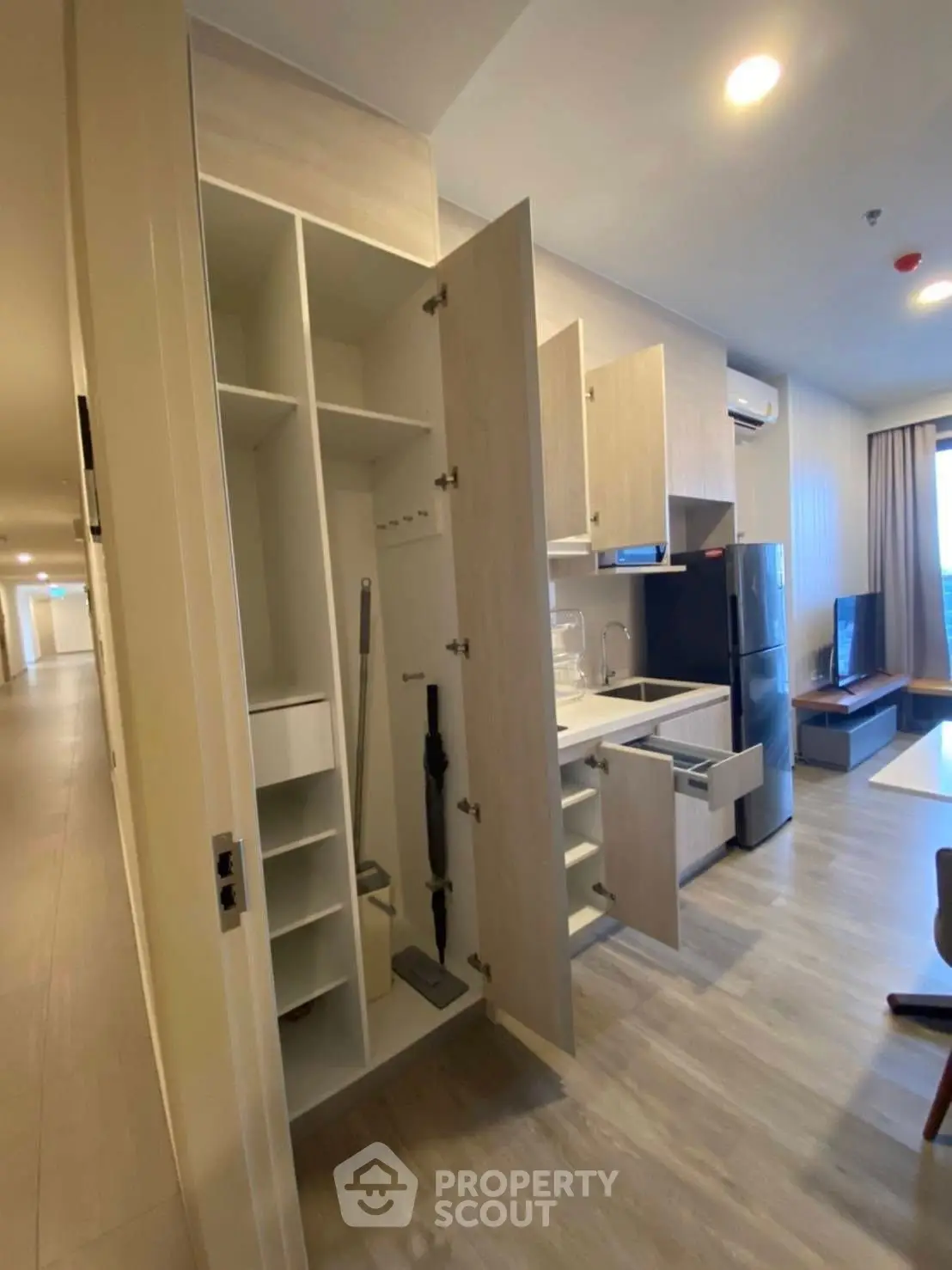 Modern apartment interior with open kitchen layout and sleek storage solutions