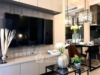 Modern living room with sleek TV setup and elegant dining area, featuring stylish decor and contemporary lighting.