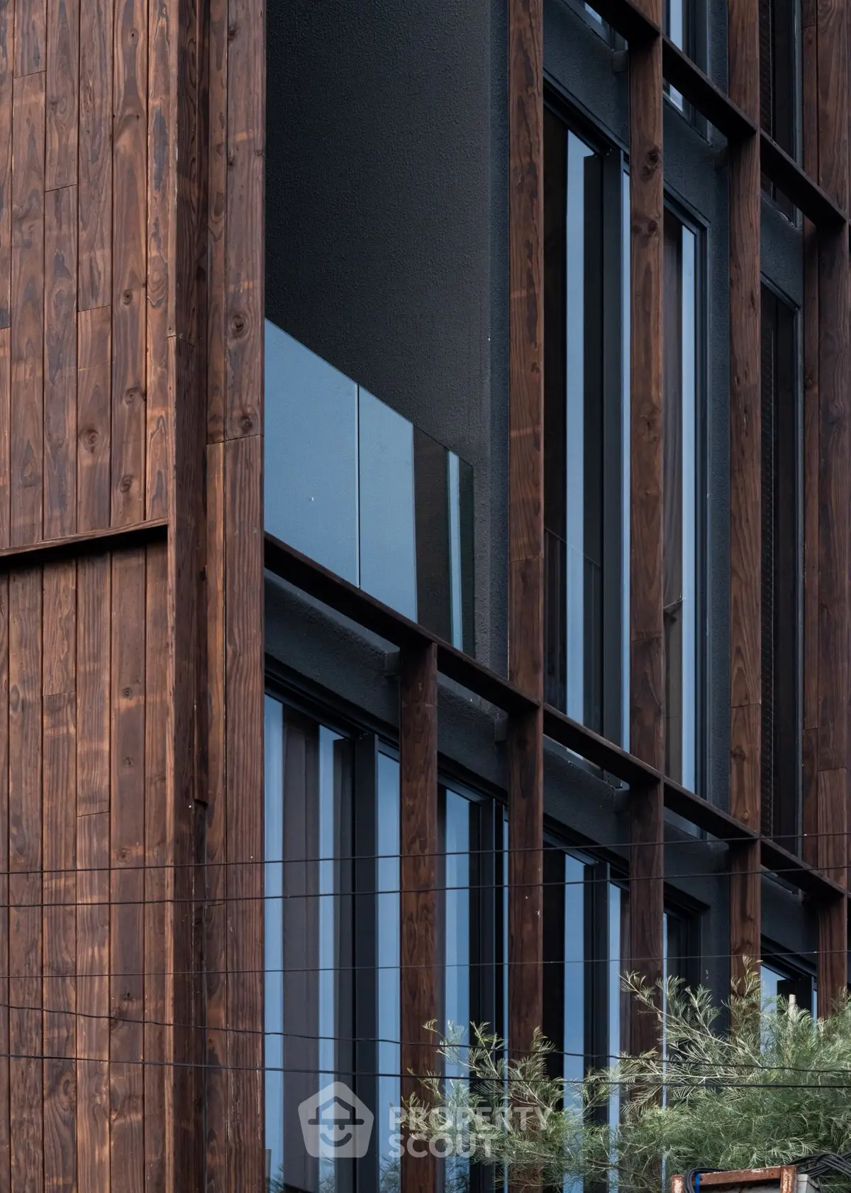 Modern architectural facade with wooden paneling and large glass windows.