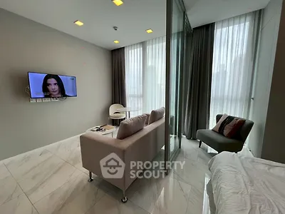 Modern living room with sleek design and large windows offering city views, featuring a cozy sofa and wall-mounted TV.