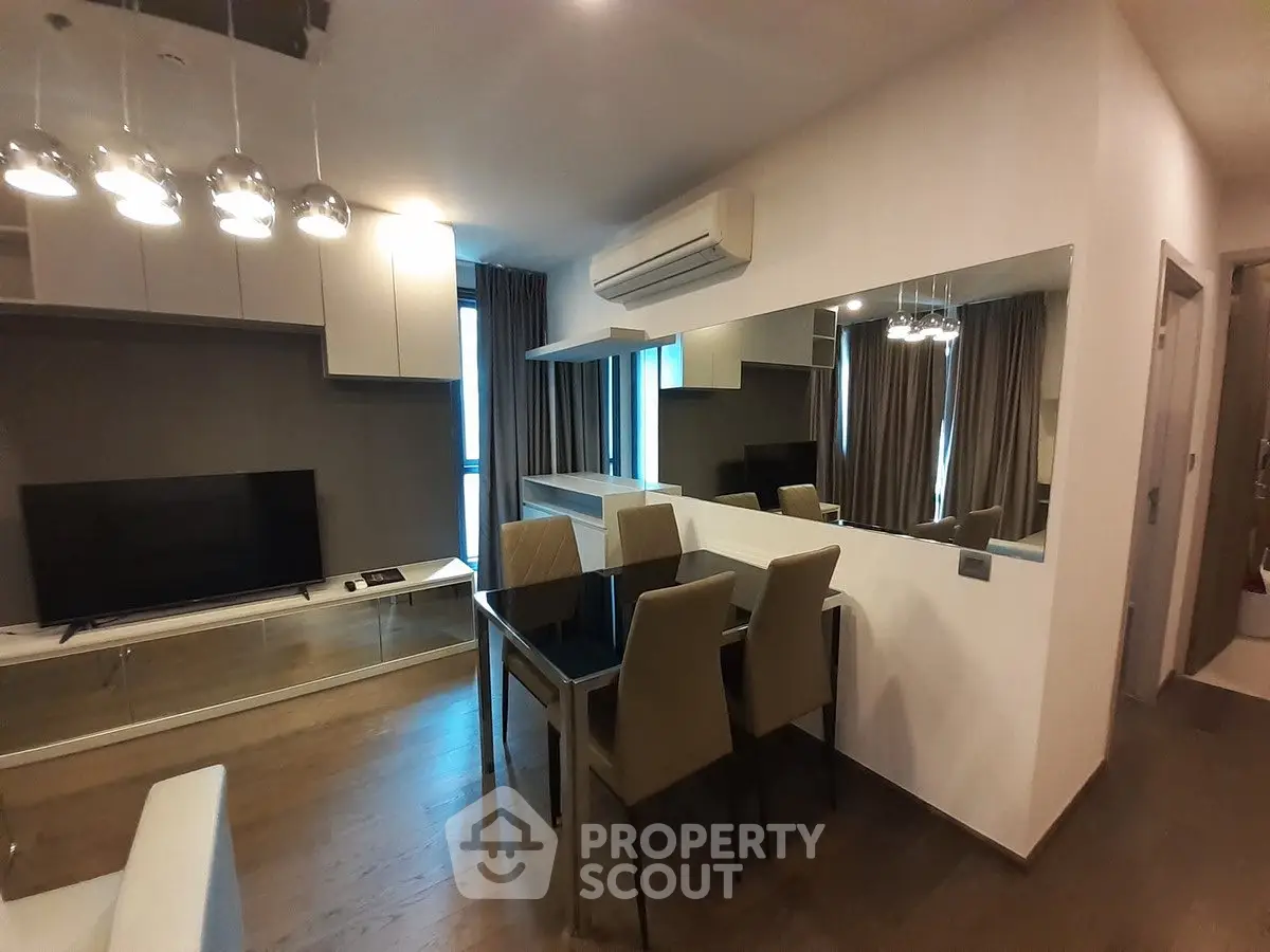 Modern living room with dining area, sleek furniture, and ambient lighting.