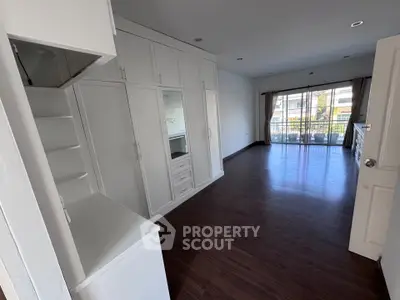 Spacious living room with built-in storage and balcony access