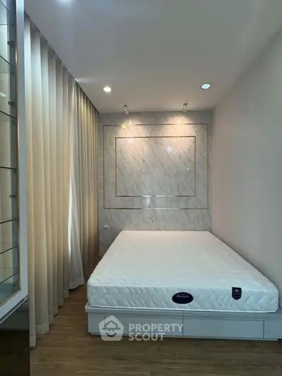 Modern bedroom with elegant marble accent wall and cozy lighting