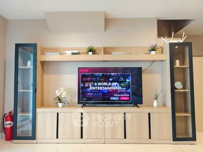 Modern living room with stylish entertainment center and large TV display.