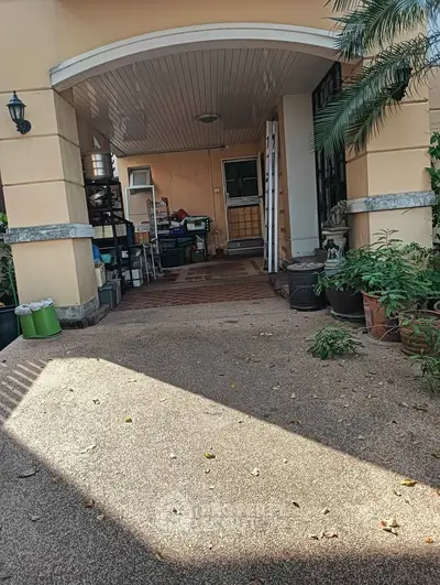Charming covered entrance with potted plants and ample storage space
