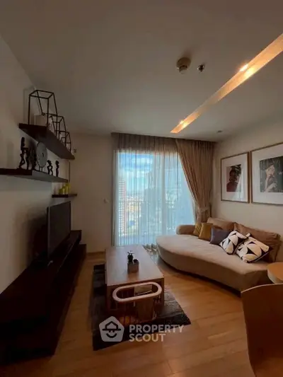 Stylish living room with modern decor and large window offering natural light.