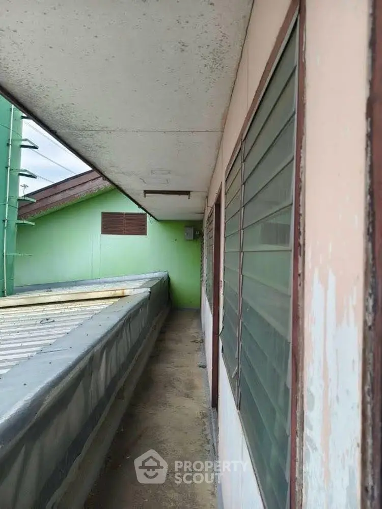 Narrow exterior corridor with windows and overhang, ideal for compact spaces.