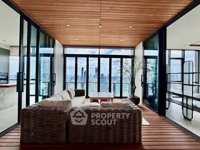 Luxurious living room with panoramic city view and elegant wicker furniture.