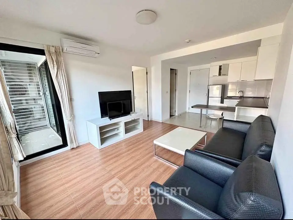 Modern living room with sleek furniture and open kitchen layout in a stylish apartment.