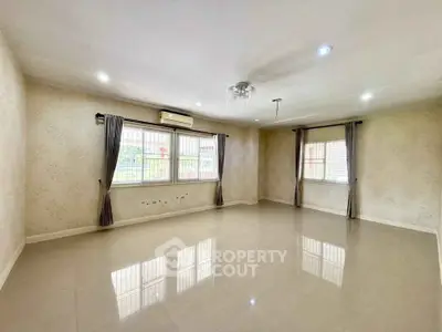 Spacious empty living room with large windows and elegant curtains, perfect for customization.