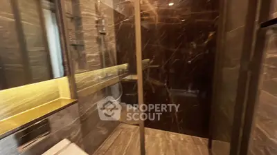 Luxurious modern bathroom with sleek marble finishes and glass shower enclosure.