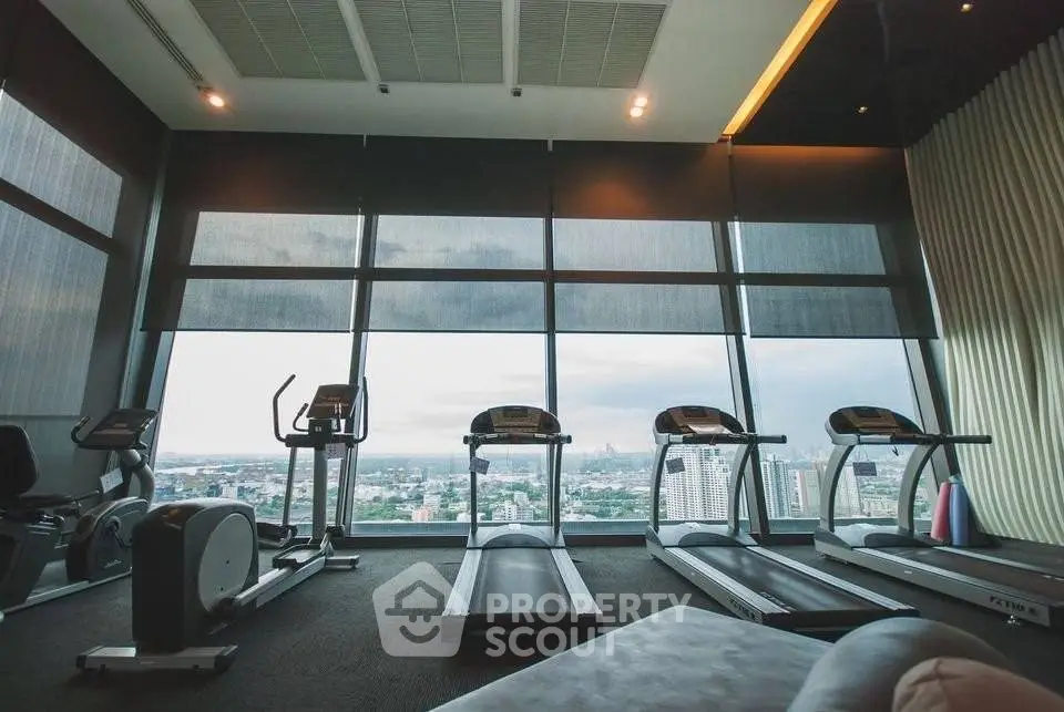 Luxurious high-rise gym with panoramic city views and modern fitness equipment.
