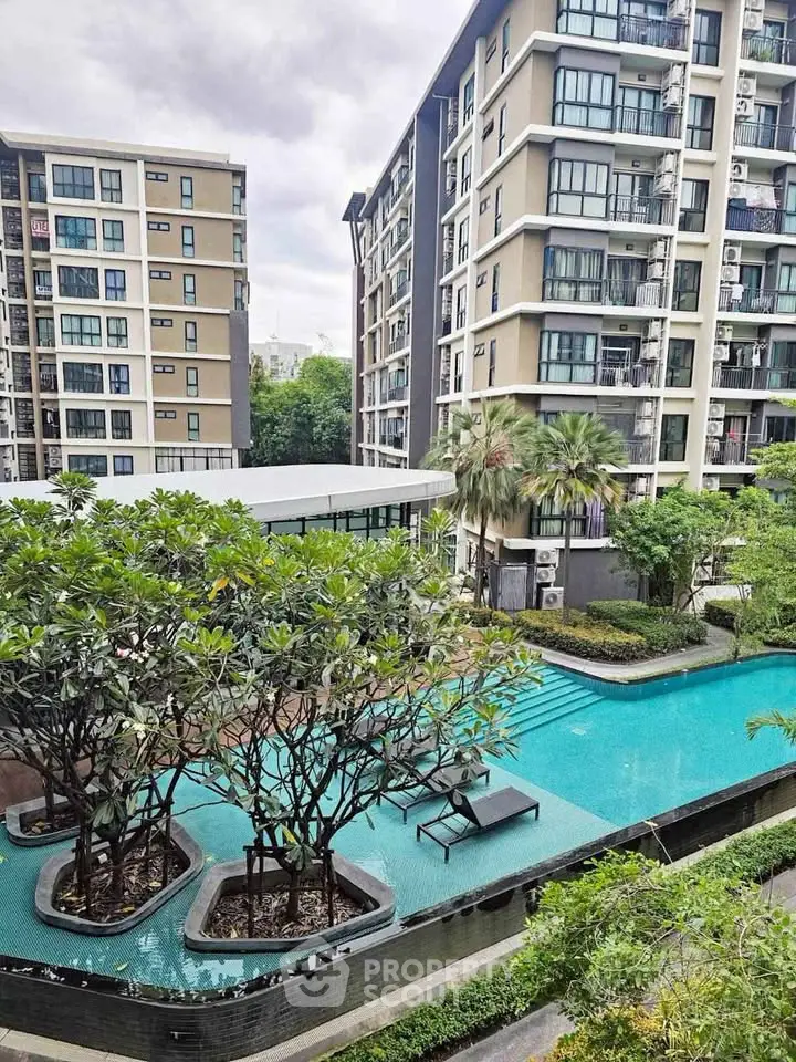 Modern apartment complex with a stunning pool and lush greenery, perfect for urban living.