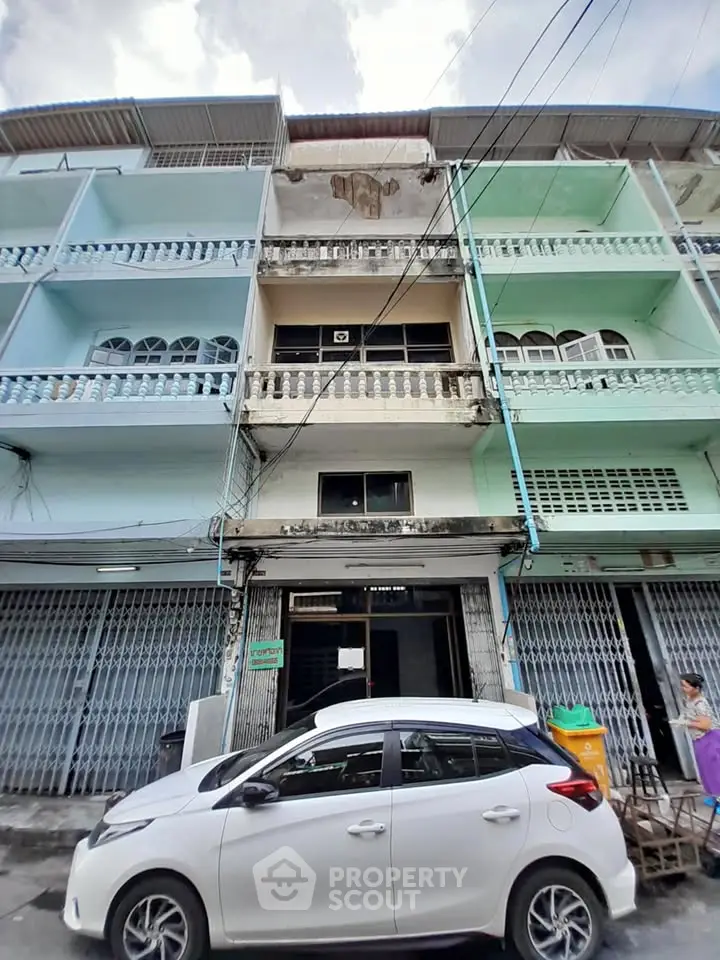 Charming multi-story building with potential, featuring unique balconies and street-level access.
