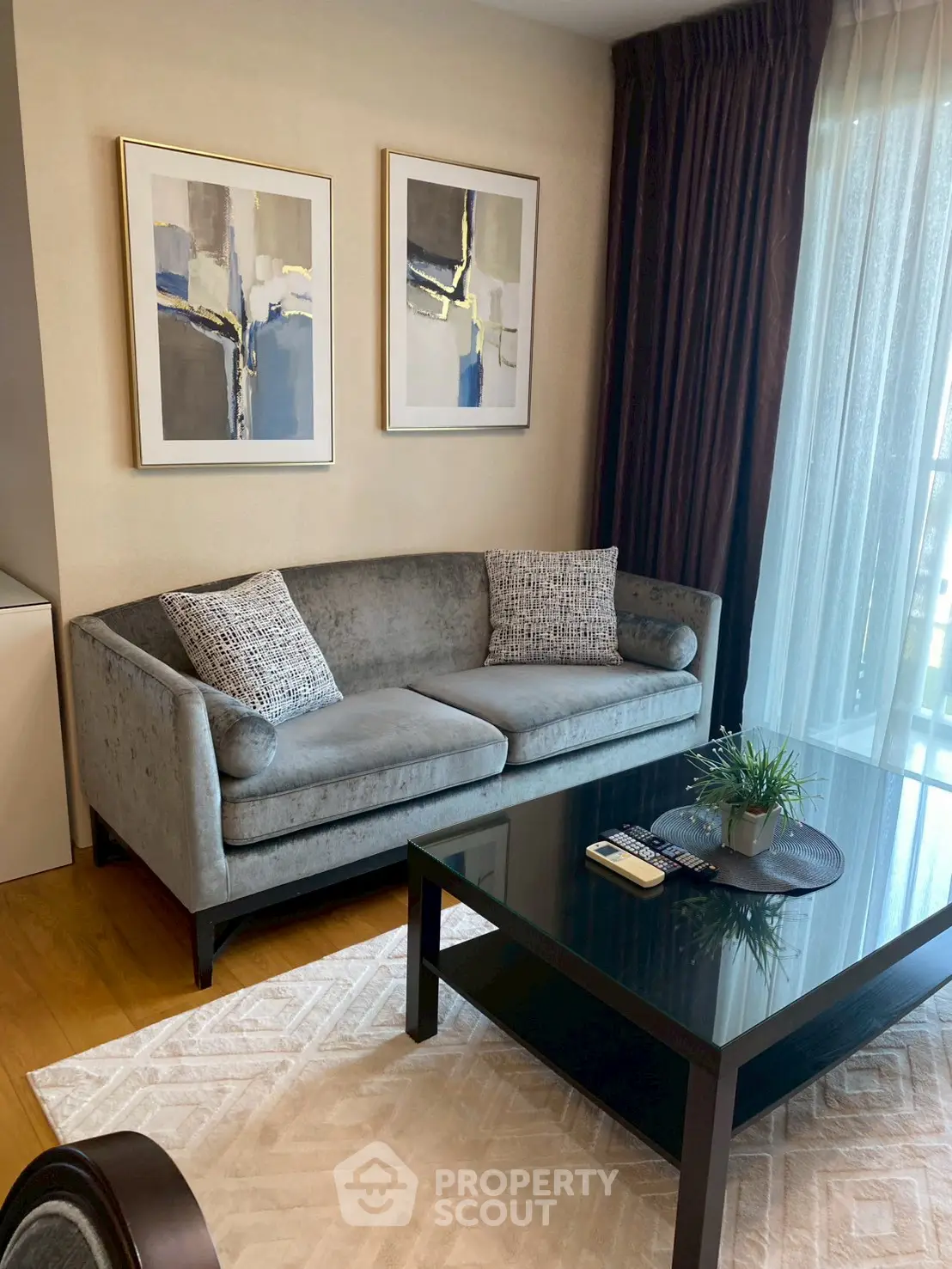 Stylish living room with modern sofa, elegant decor, and natural light through large windows.