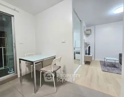 Modern apartment interior with dining area and living room, featuring sleek furniture and neutral tones.
