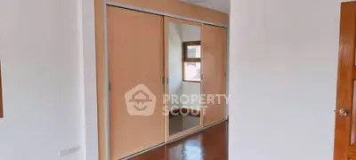 Spacious bedroom with elegant wooden sliding closet doors and polished floors.