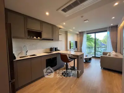 Modern open-layout kitchen and living room with natural light and stylish decor.