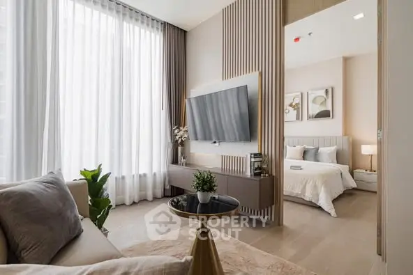 Modern living room with elegant decor and view into cozy bedroom