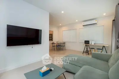 Modern living room with wall-mounted TV and cozy seating area