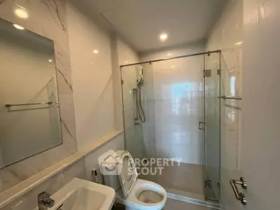 Modern bathroom with glass shower enclosure and sleek fixtures