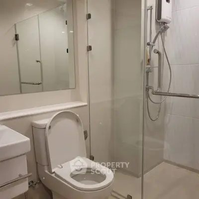Modern bathroom with glass shower and sleek fixtures in contemporary apartment.
