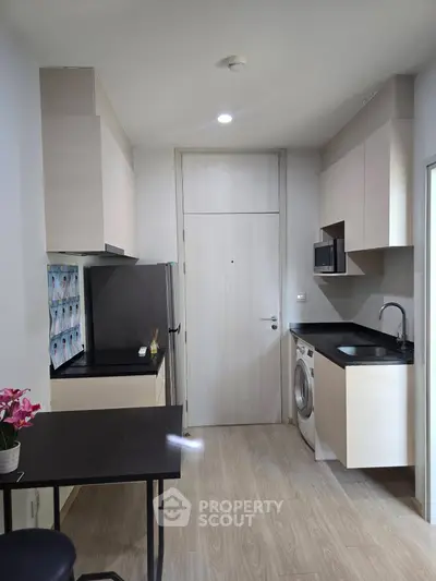 Modern compact kitchen with sleek cabinetry and integrated appliances in a stylish apartment.