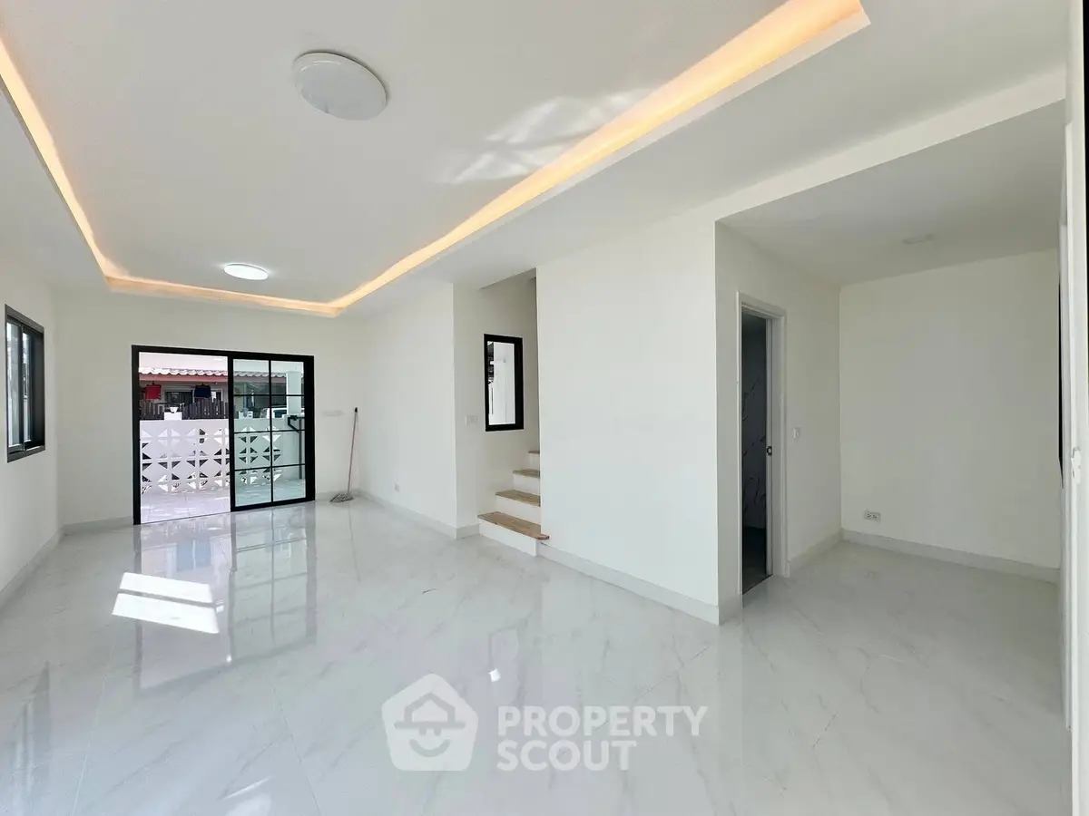 Spacious modern living room with sleek white flooring and ambient lighting